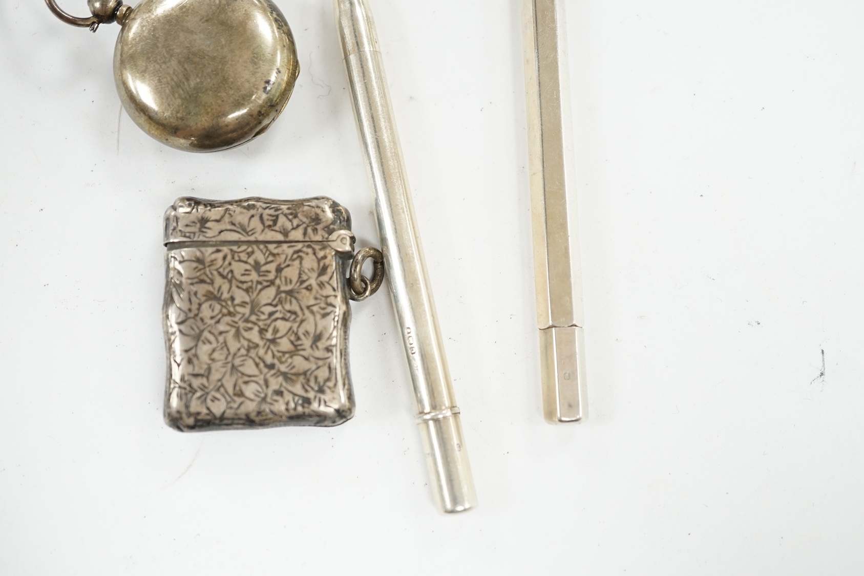 A George V silver sovereign case, a silver vesta case and two silver propelling pencils. Condition - poor to fair